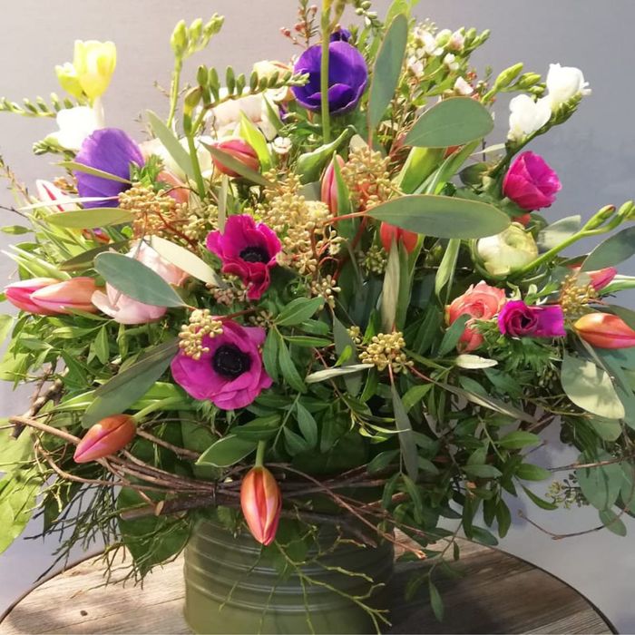 eine Vase voller Blumen steht auf einem Holztisch