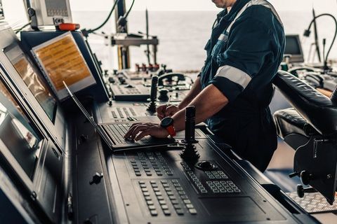 man working on laptop on a boat