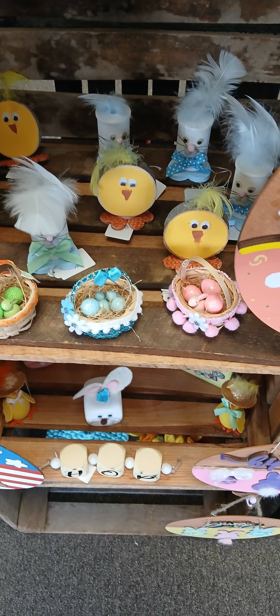 Cute chick-themed crafts and trinkets displayed on wooden shelves at a market stall