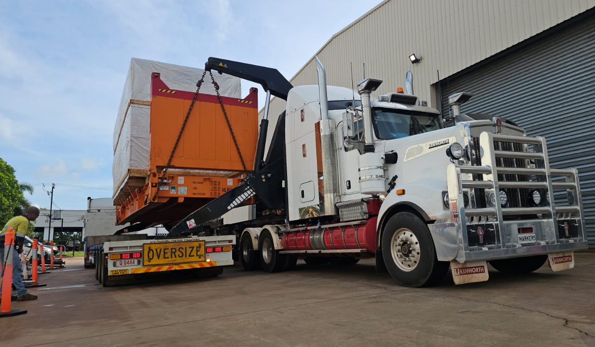 A Semi Truck is Carrying a Large Orange Box on a Trailer — Harker Haulage In East Arm, NT