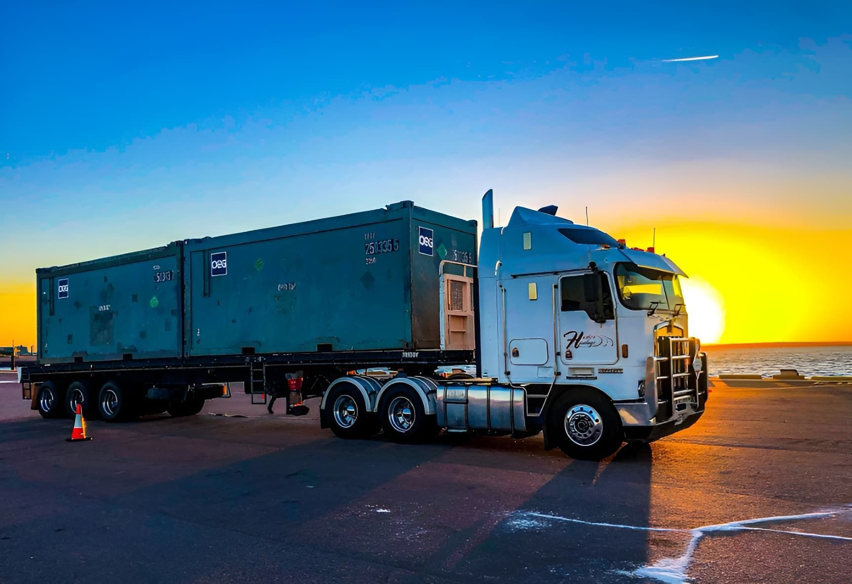 A Semi Truck is Parked on the Side of the Road at Sunset — Harker Haulage In Howard Springs, NT A Semi Truck is Parked on the Side of the Road at Sunset — Harker Haulage In Howard Springs, NT