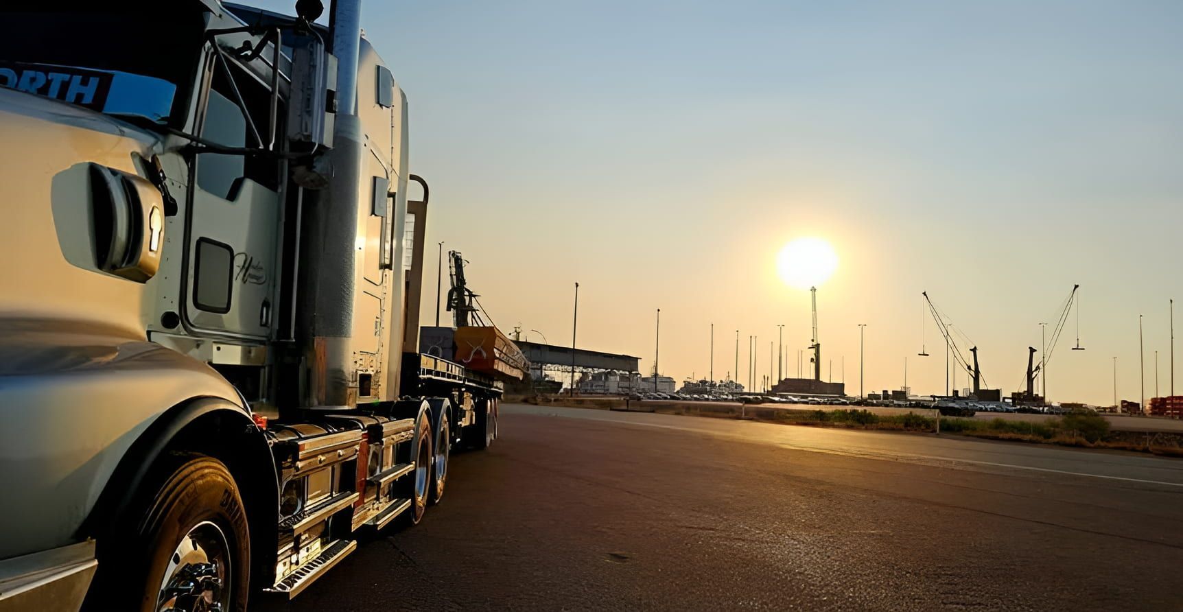 A semi truck is parked on the side of the road at sunset — Harker Haulage In East Arm, NT