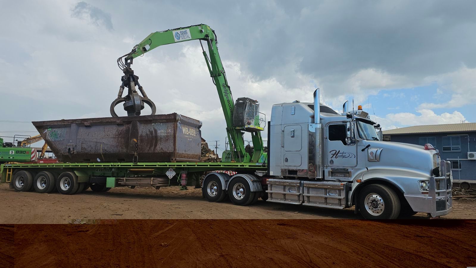 A truck with a green crane lifting a large metal container in an outdoor setting. — Harker Haulage In East Arm, NT