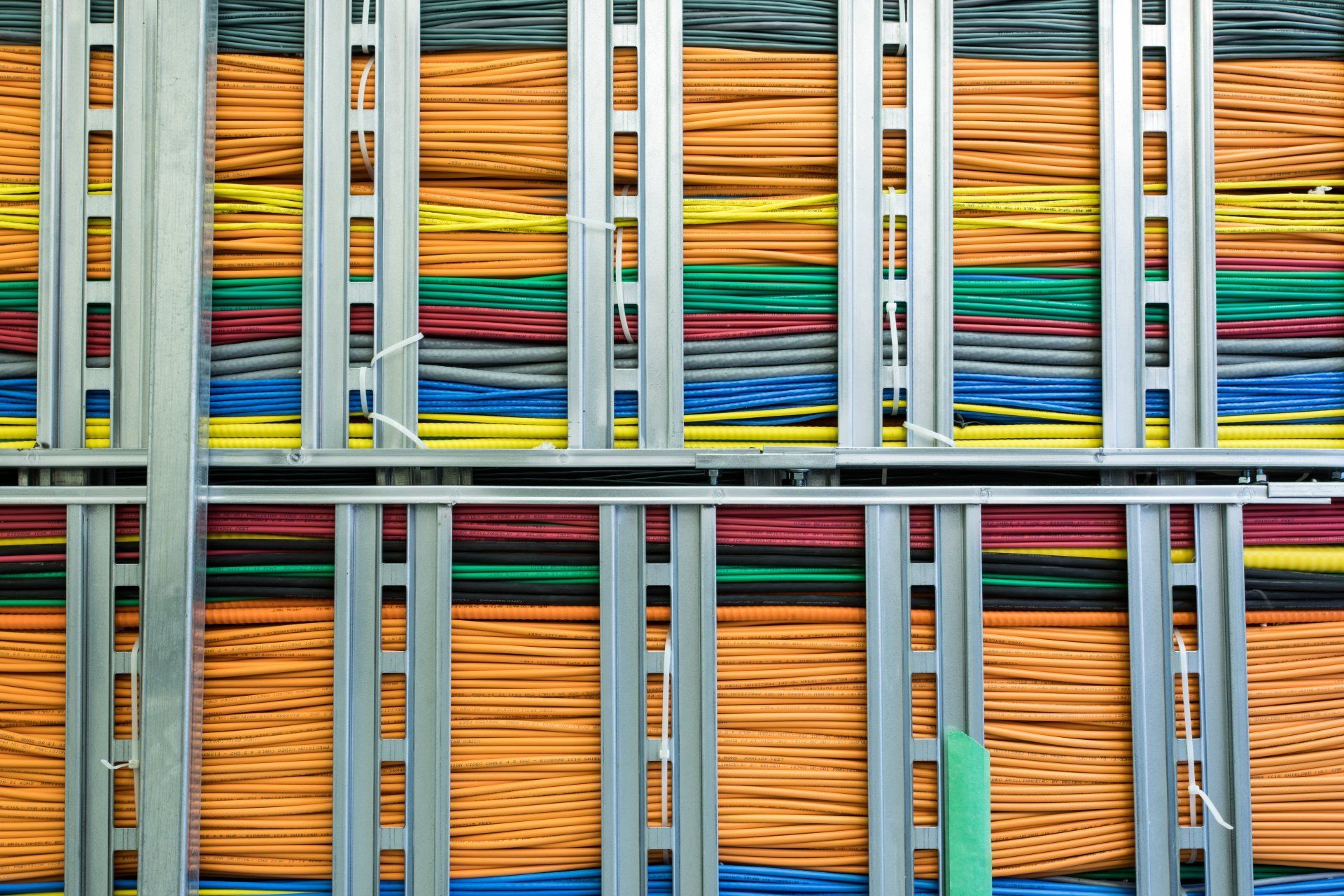 Colorful network cables neatly organized in a metal rack.