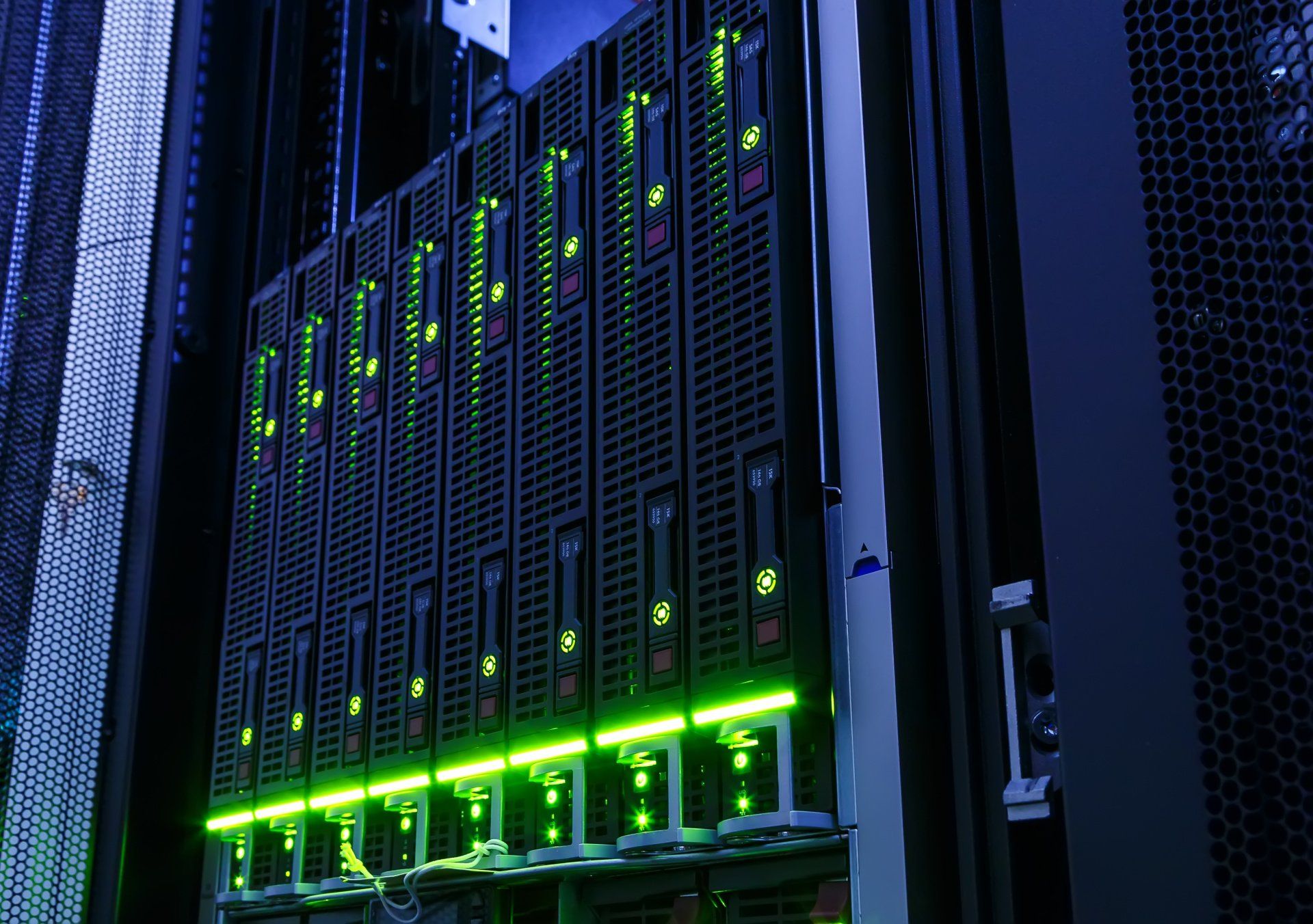 A row of servers in a data center with green lights on them.