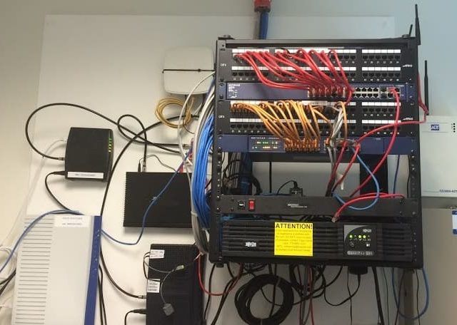 A bunch of wires are connected to a server rack