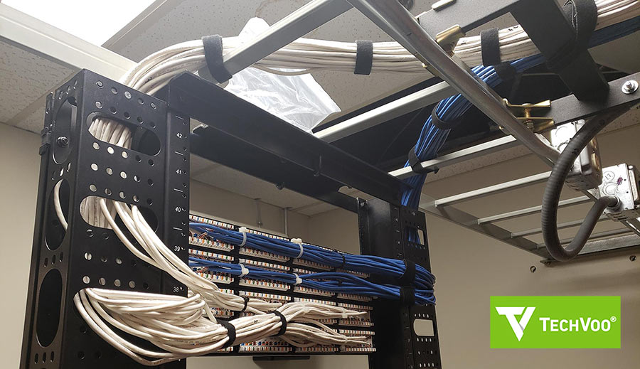 Black server rack with organized network cables, running above and through the rack.