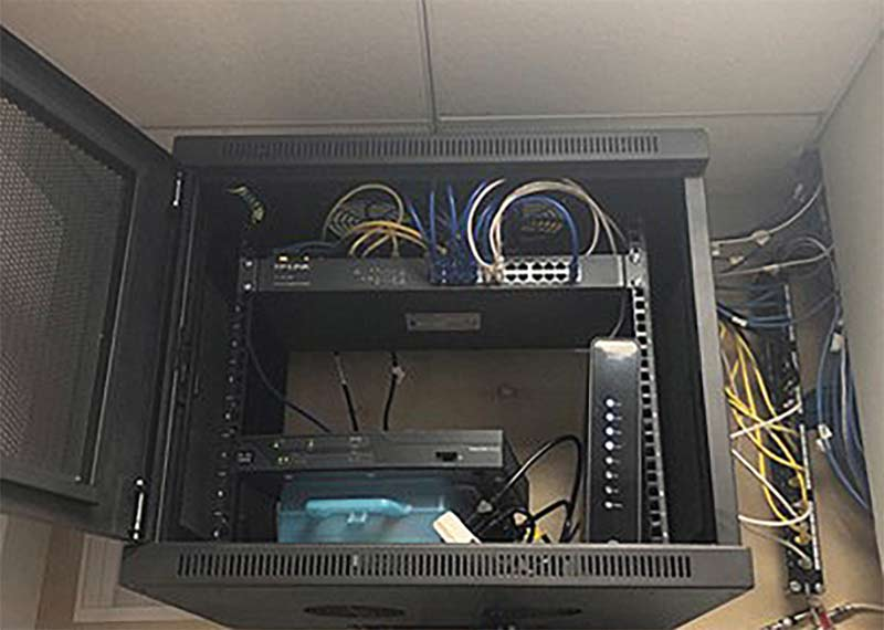 Server rack in a cabinet with network equipment and cables.
