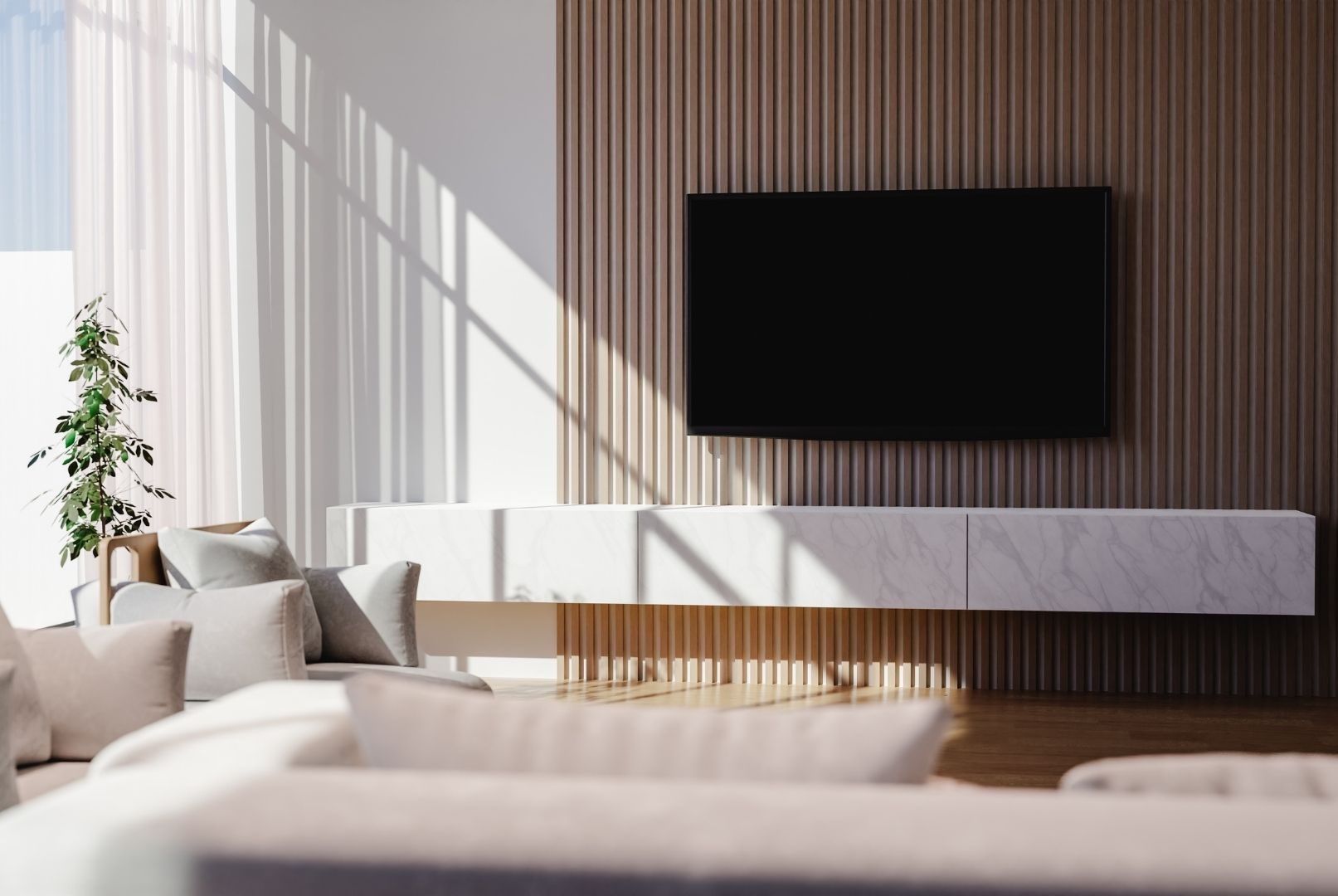 A living room with a couch and a flat screen tv on the wall.