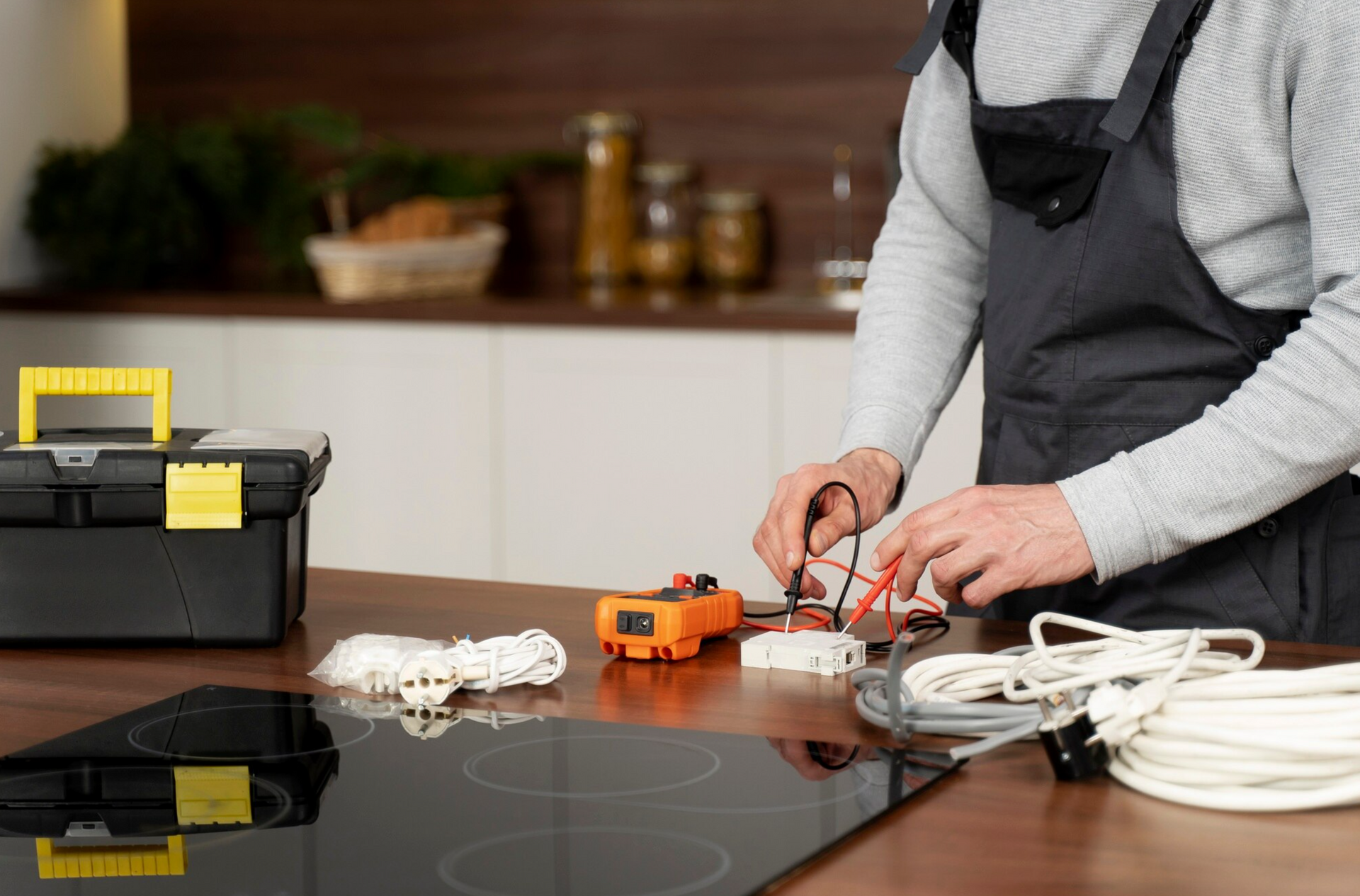 A man is fixing a stove top oven in a kitchen.