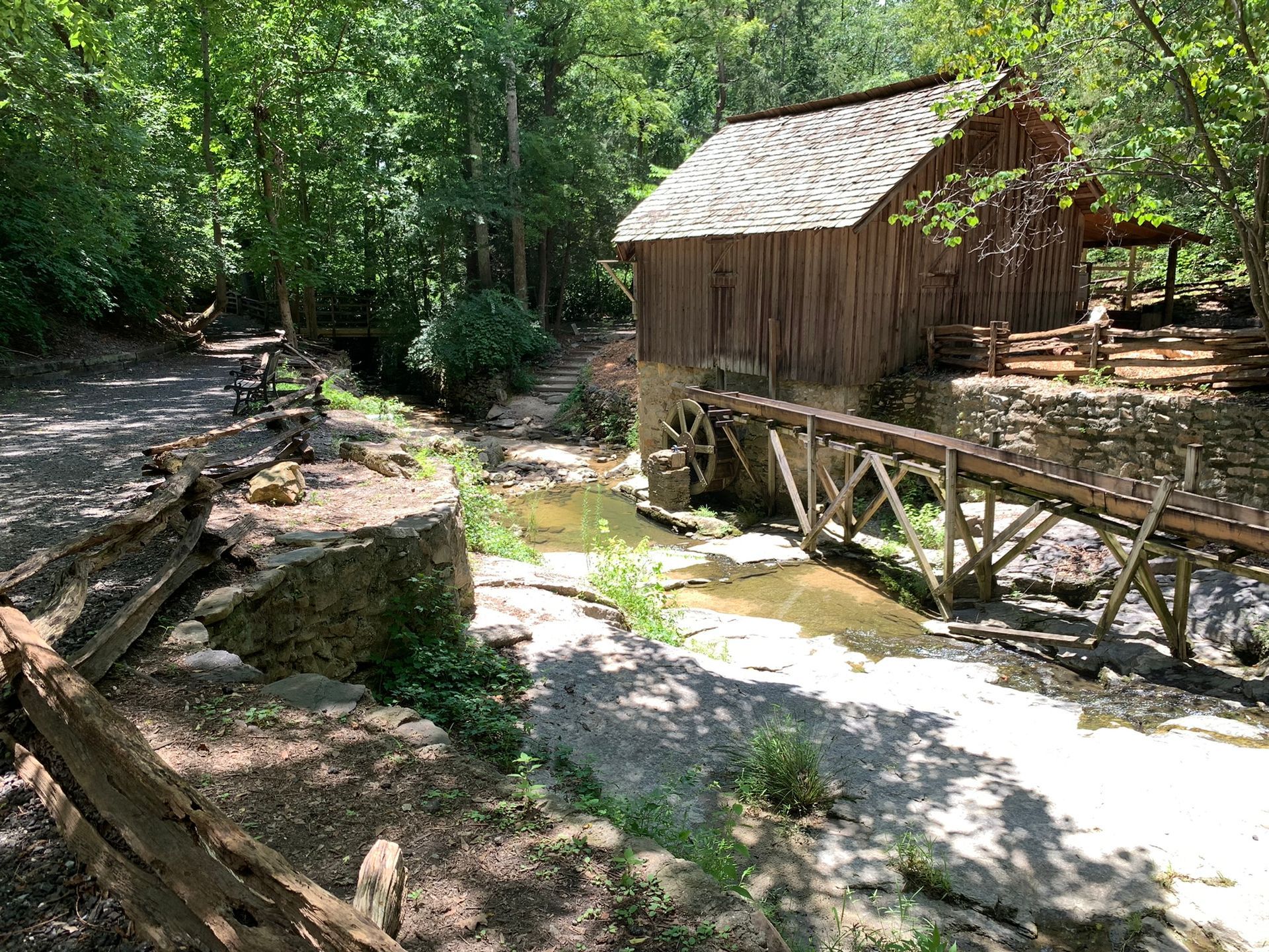 Outside photo of historic building with babbling creek and water wheel