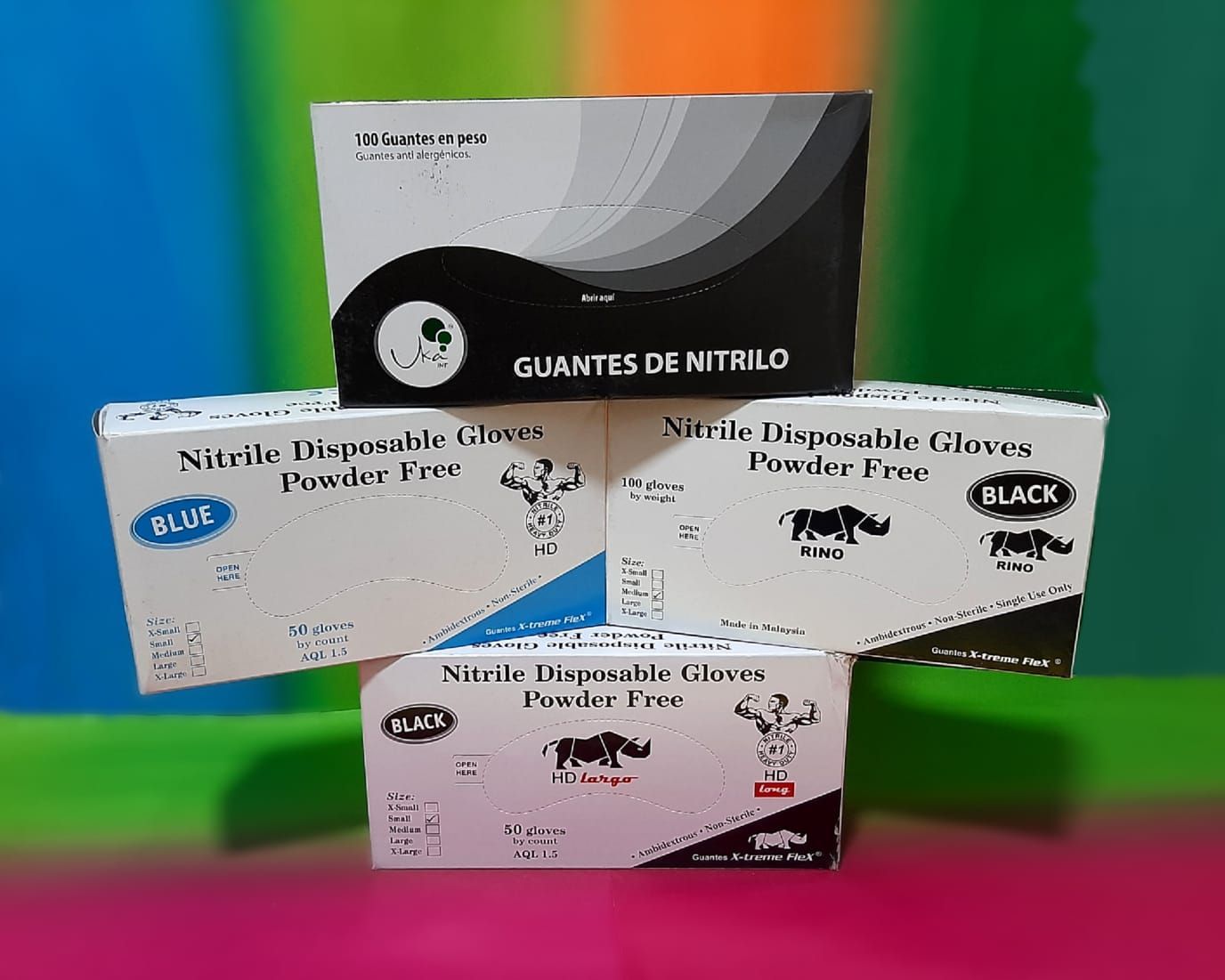 Un montón de cajas de guantes están apiladas una encima de otra sobre una mesa.