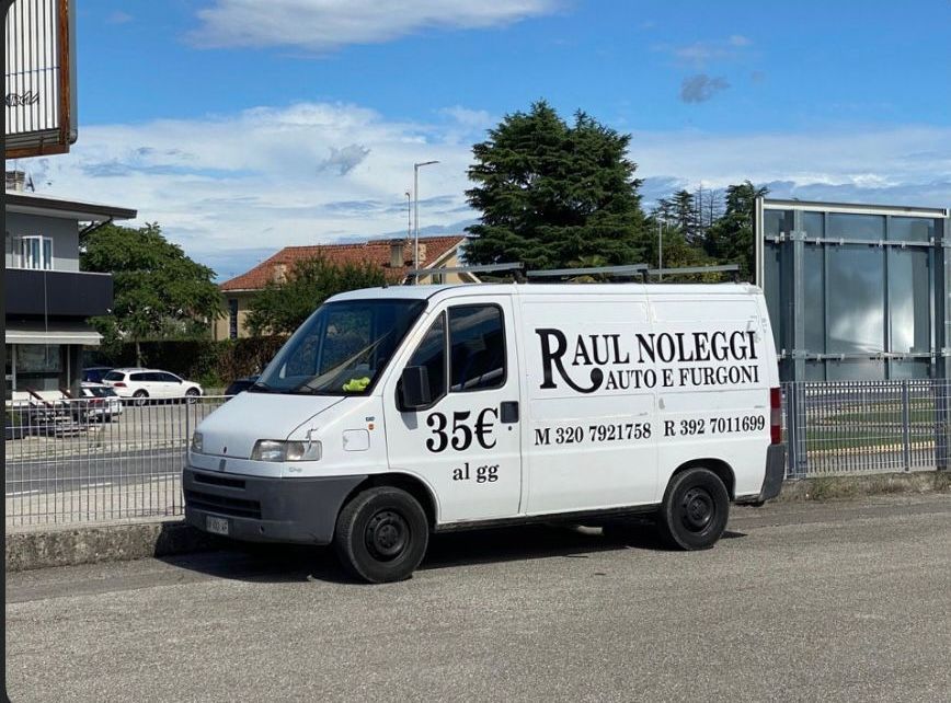 Una Ford C-Max bianca è parcheggiata su un vialetto in mattoni di fronte a una casa.