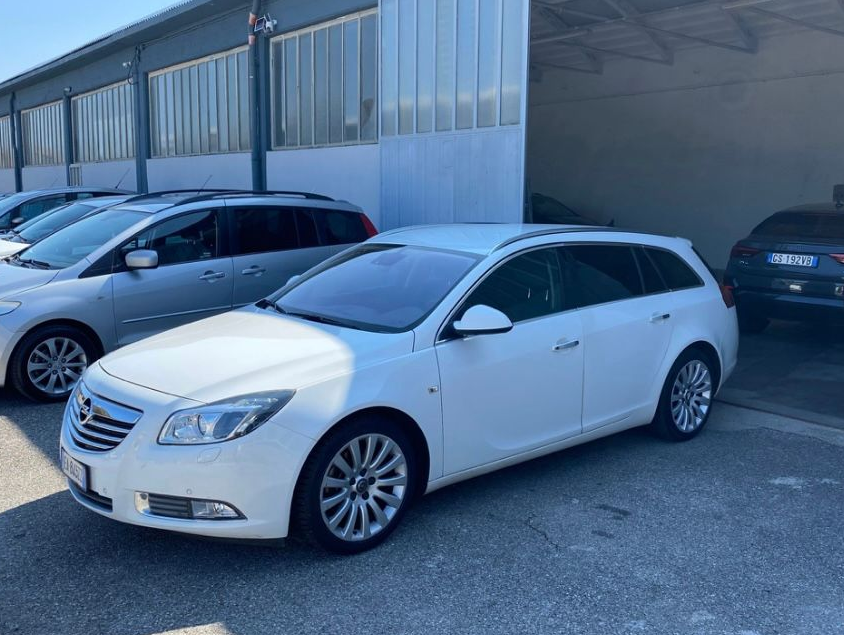 Una Mercedes Benz Classe C Station Wagon bianca è parcheggiata su un vialetto in mattoni.