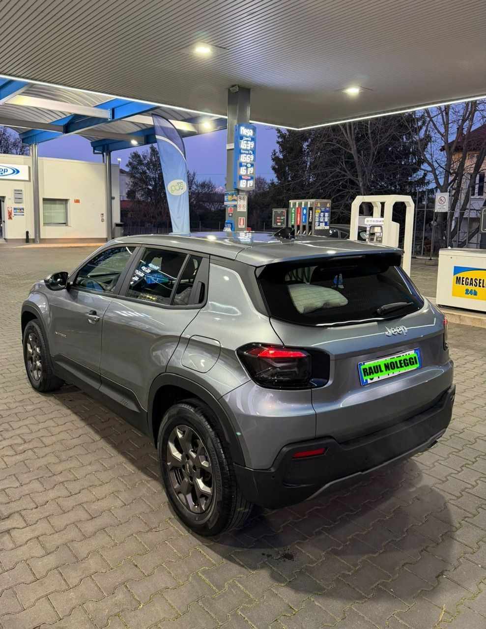 Una Mercedes Benz Classe C Station Wagon bianca è parcheggiata su un vialetto in mattoni.