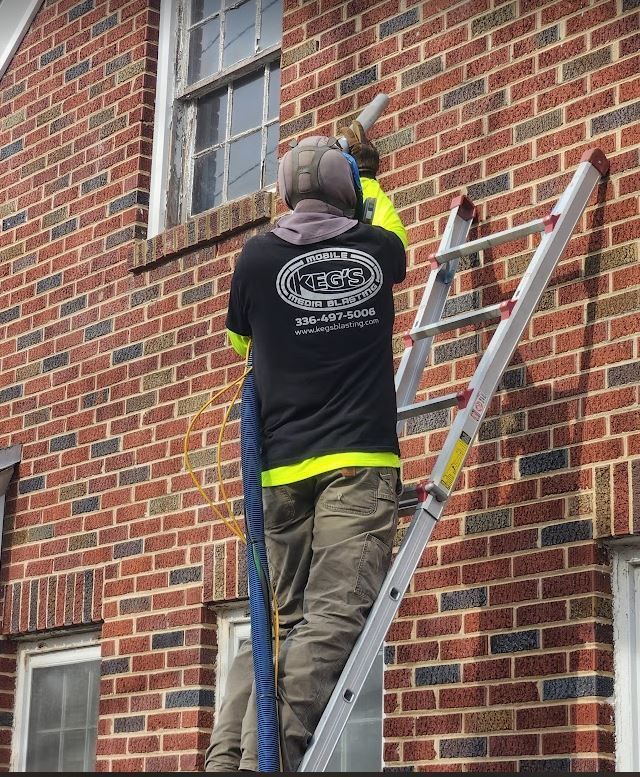 a man is removing soot from a brick building
