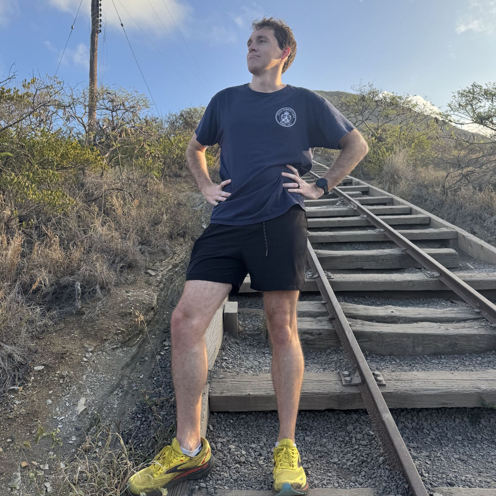 A man standing on train tracks with his hands on his hips
