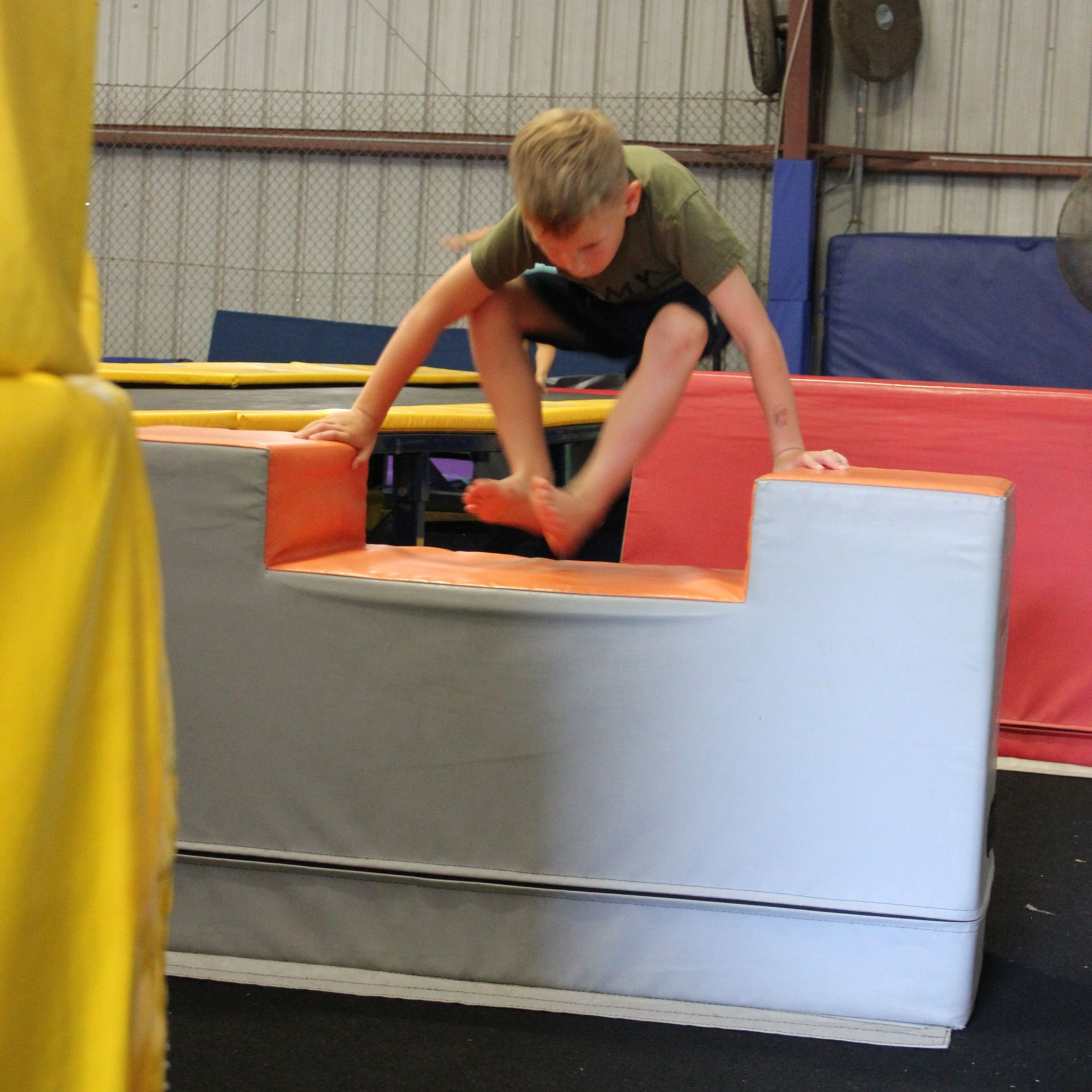 A young boy with a medal around his neck is flexing his muscles.