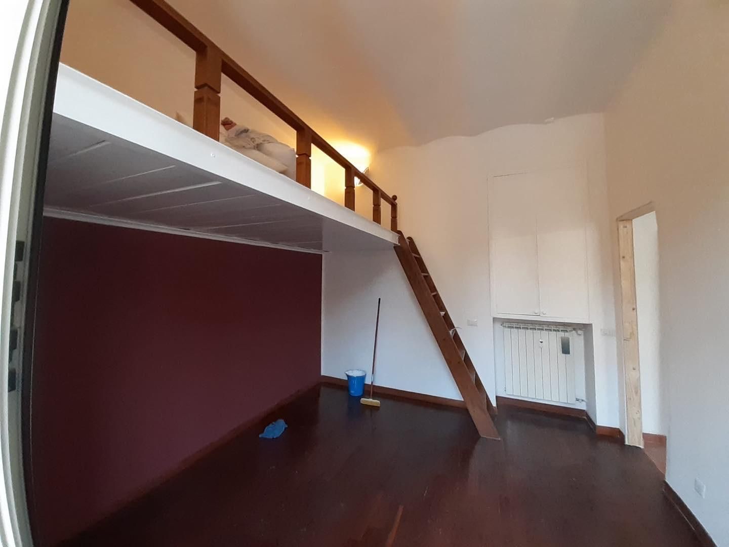 Una stanza vuota con una scala che porta a un letto a soppalco