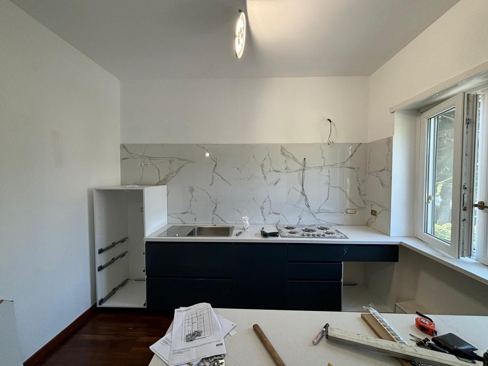 Una cucina in costruzione con un lavandino e una finestra