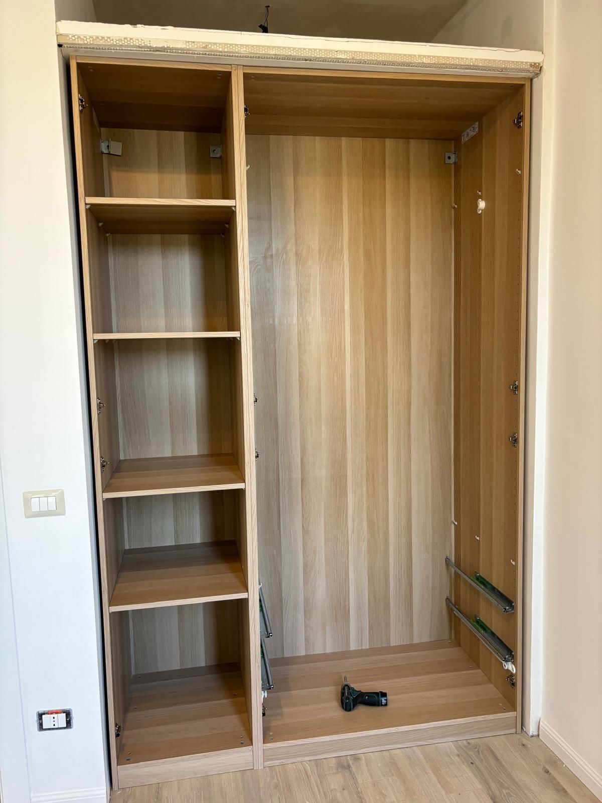 In una stanza viene costruito un armadio di legno.