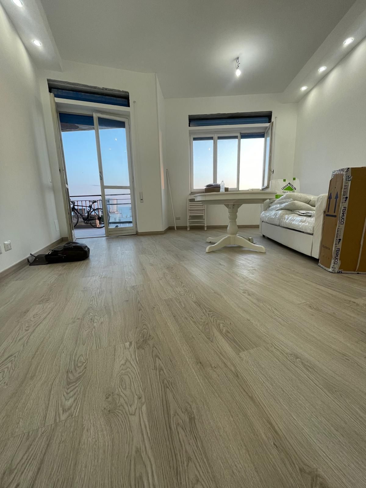 Un soggiorno con divano, tavolo e porte scorrevoli in vetro.