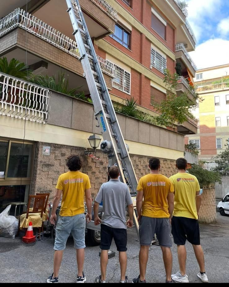 Un gruppo di uomini in piedi davanti a un edificio con una scala sullo sfondo