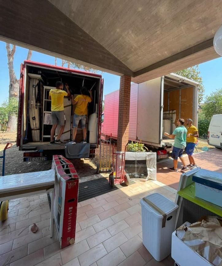 Un uomo con una maglietta gialla è in piedi davanti a un camion rosso