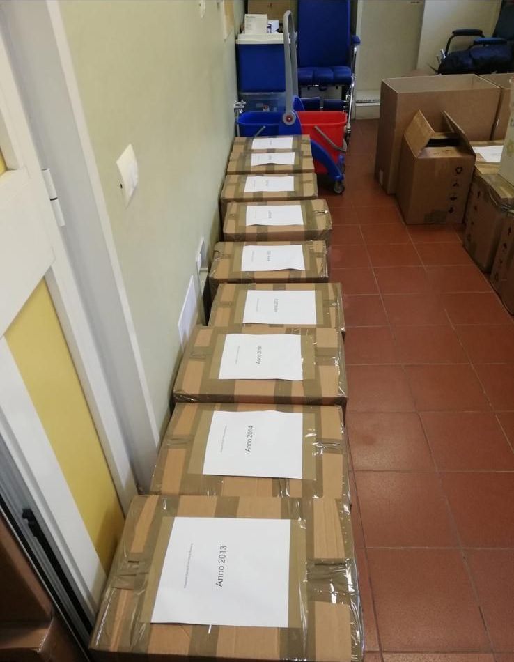 Diverse scatole di cartone sono allineate in un corridoio e una di queste ha un'etichetta che dice