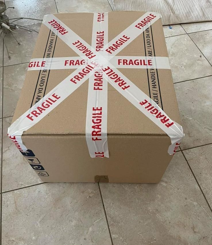 Una scatola di cartone con del nastro adesivo fragile intorno