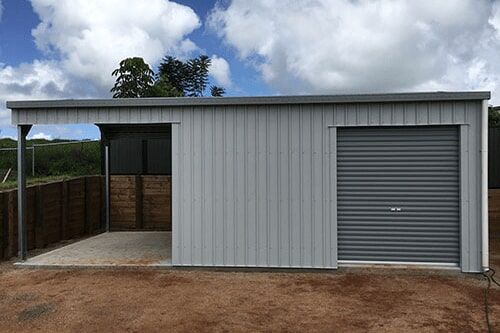 A Shed With A Garage Attached To It Is Sitting On Top Of A Dirt Field — Dunnrite Mareeba Sheds & Garages In Mareeba, QLD