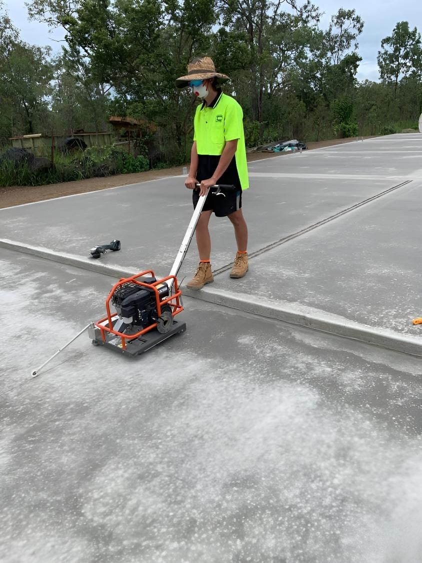 A Man Is Using A Machine On A Concrete Surface — Dunnrite Mareeba Sheds & Garages In Mareeba, QLD