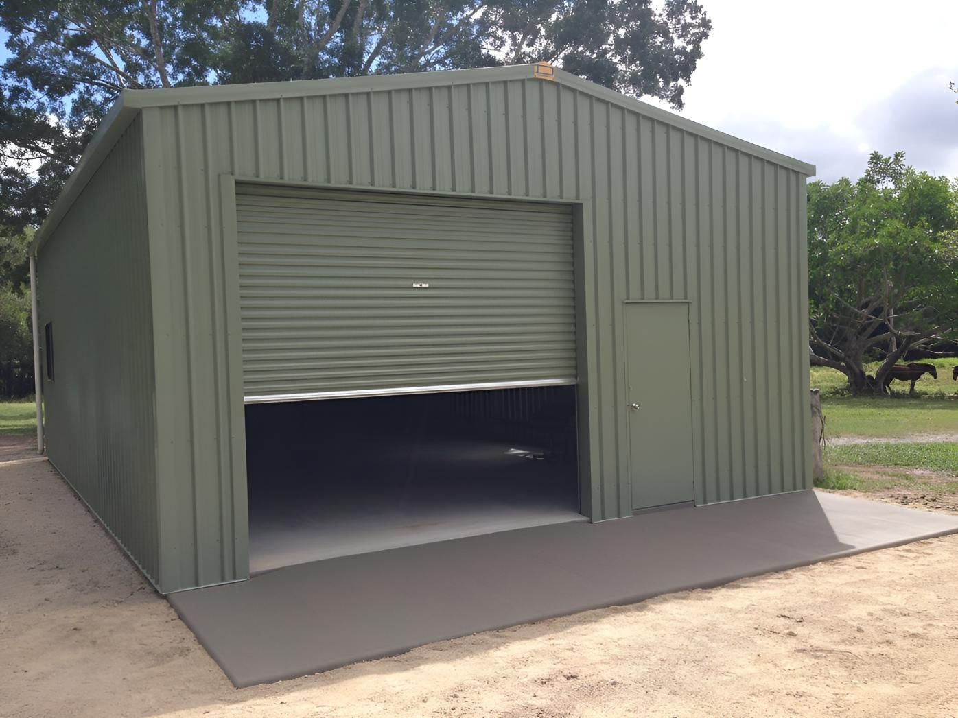 A Green Garage With A Roll Up Door And A Ramp — Dunnrite Mareeba Sheds & Garages In Mareeba, QLD