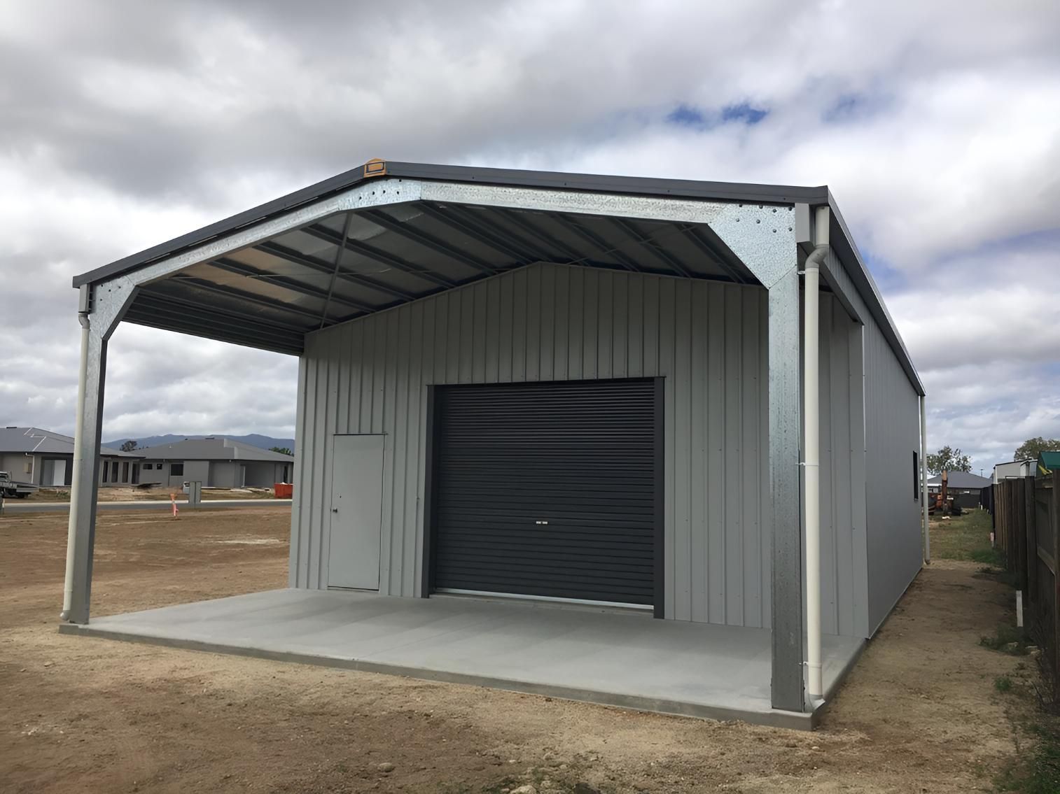 A Metal Garage With A Black Garage Door And A Concrete Floor — Dunnrite Mareeba Sheds & Garages In Mareeba, QLD