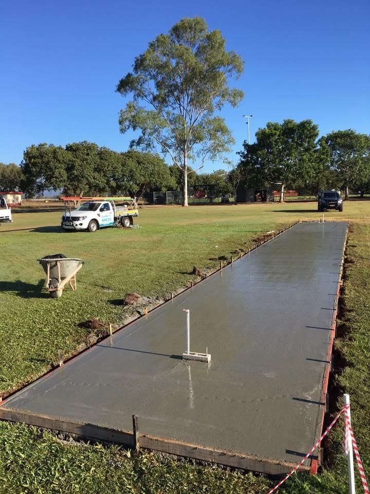 A Large Concrete Slab Is Being Built In A Grassy Field — Dunnrite Mareeba Sheds & Garages In Mareeba, QLD