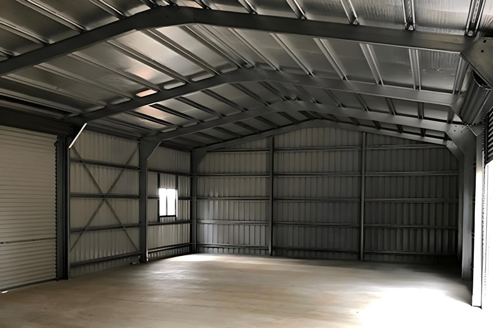 A Large Empty Warehouse With A Metal Roof And A Window — Dunnrite Mareeba Sheds & Garages In Mareeba, QLD