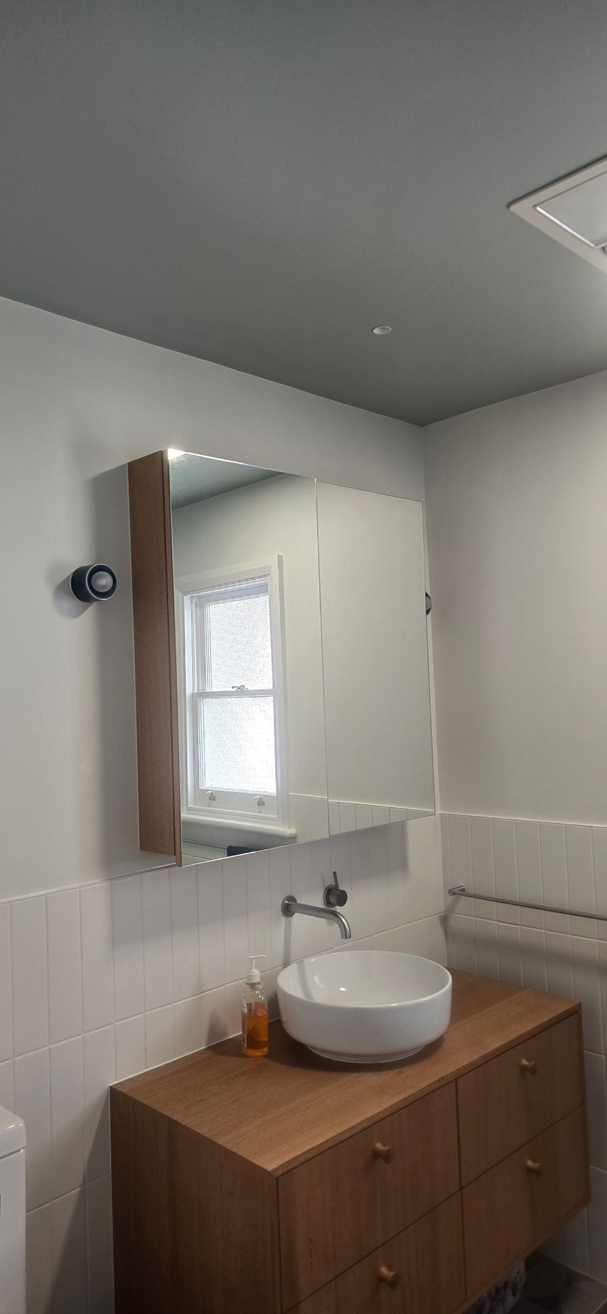 A bathroom with a sink , mirror and medicine cabinet.