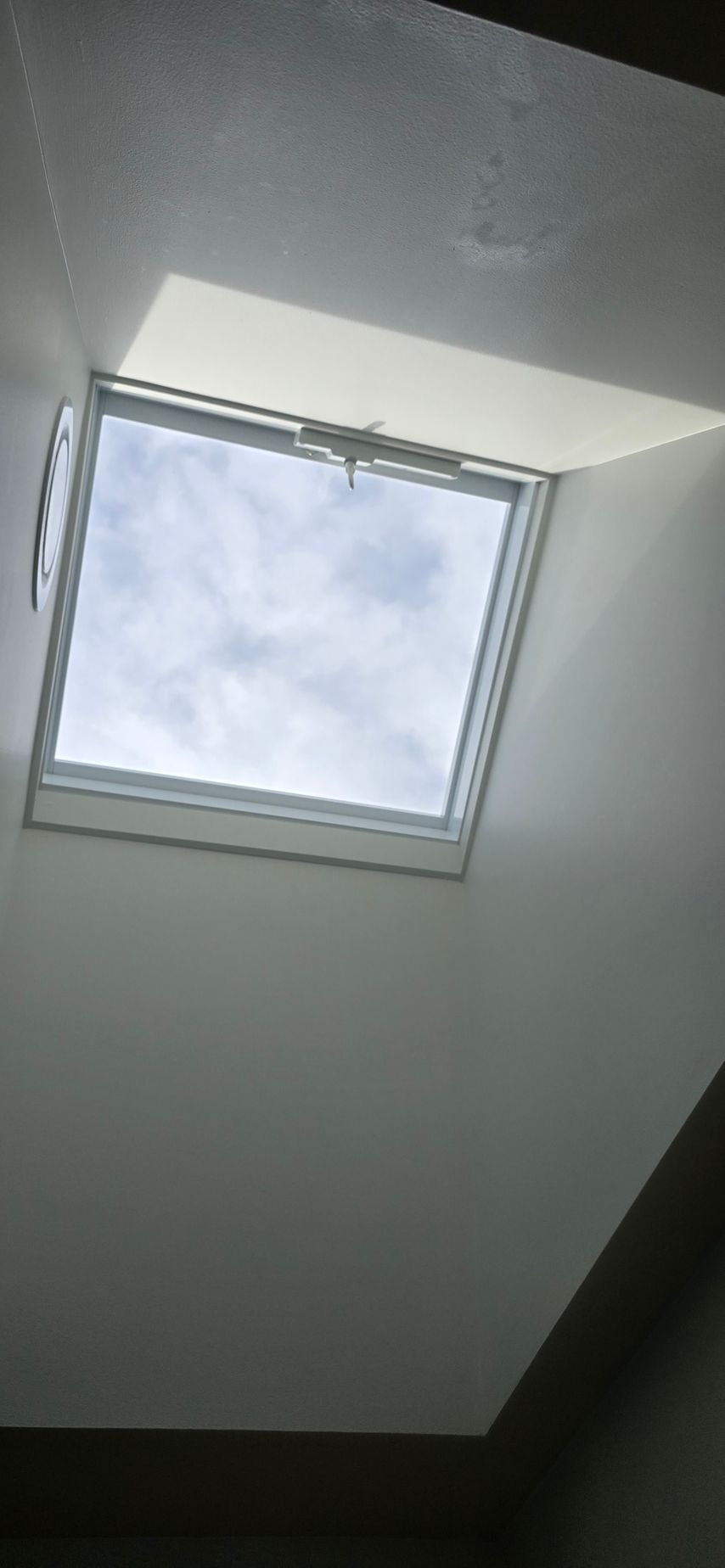 There is a skylight in the ceiling that looks like a window.