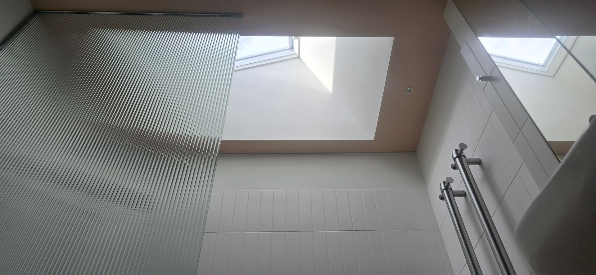 A bathroom with a skylight and a shower curtain