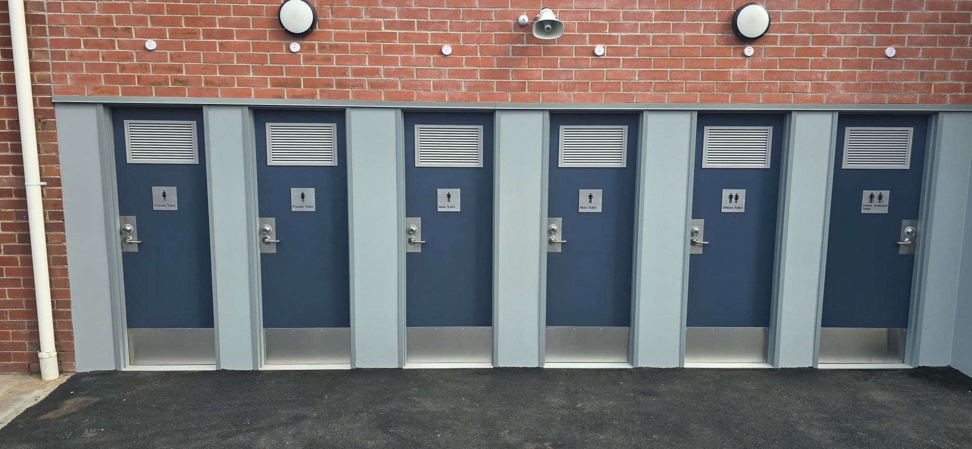 A row of lockers are lined up in front of a brick building
