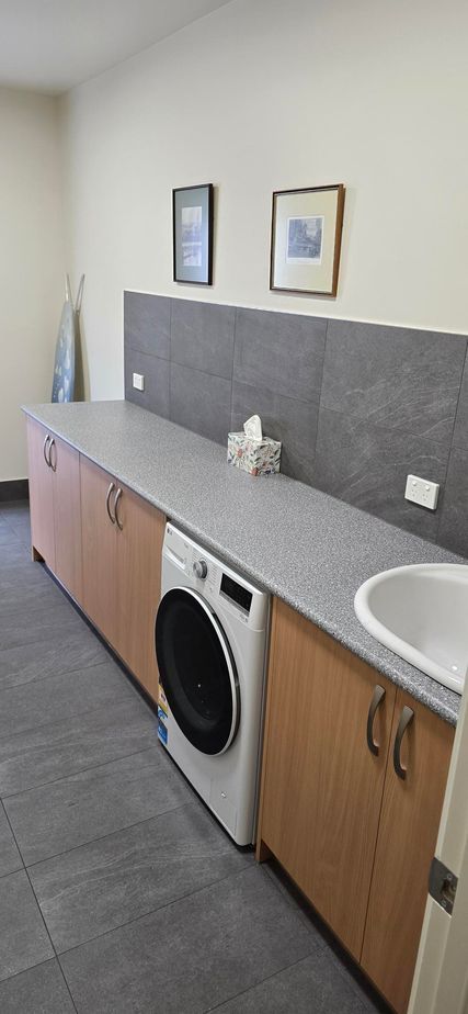 A laundry room with a washer and dryer and a sink.