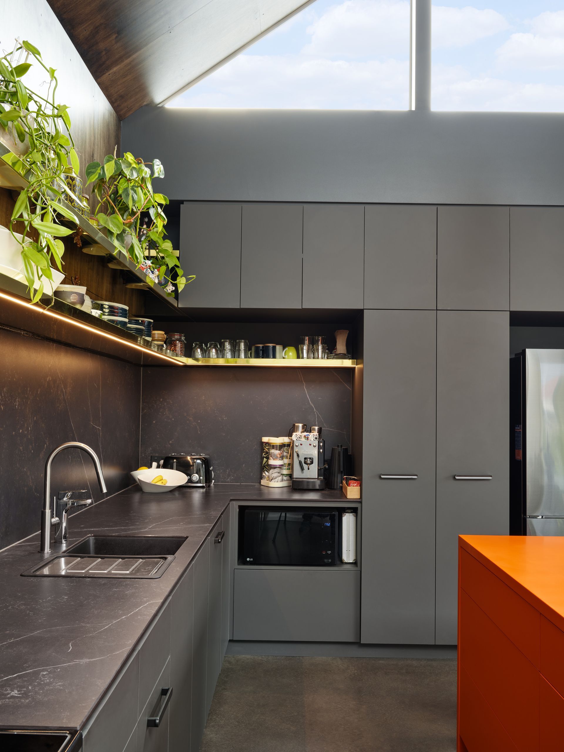 A kitchen with a sink a microwave and a window