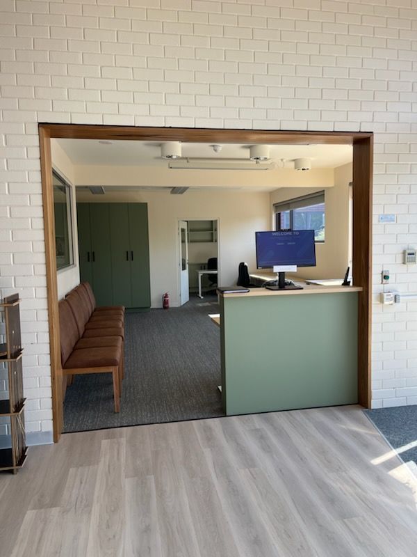 A room with a brick wall and a desk with a computer on it