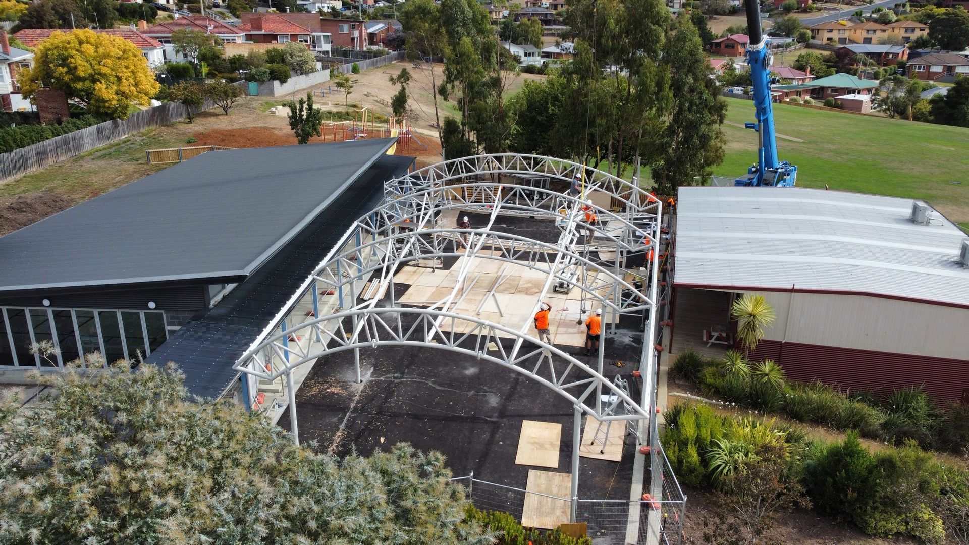 An aerial view of a building under construction with a crane in the background.