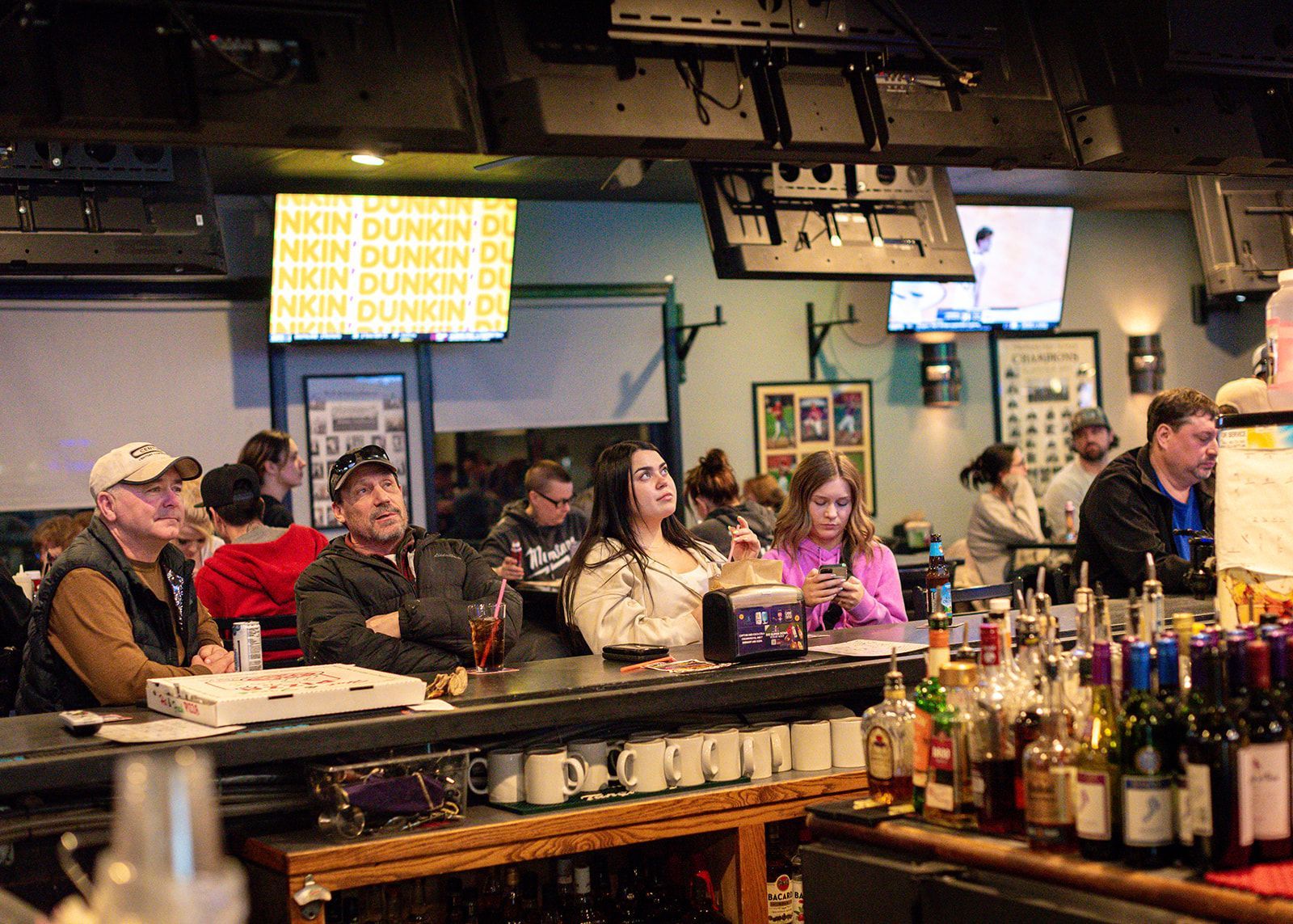 A group of people are sitting at a bar in a restaurant.
