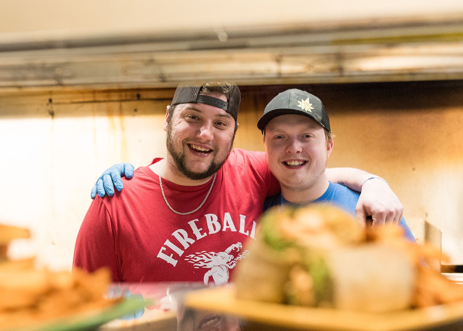 Two men are posing for a picture in a restaurant.