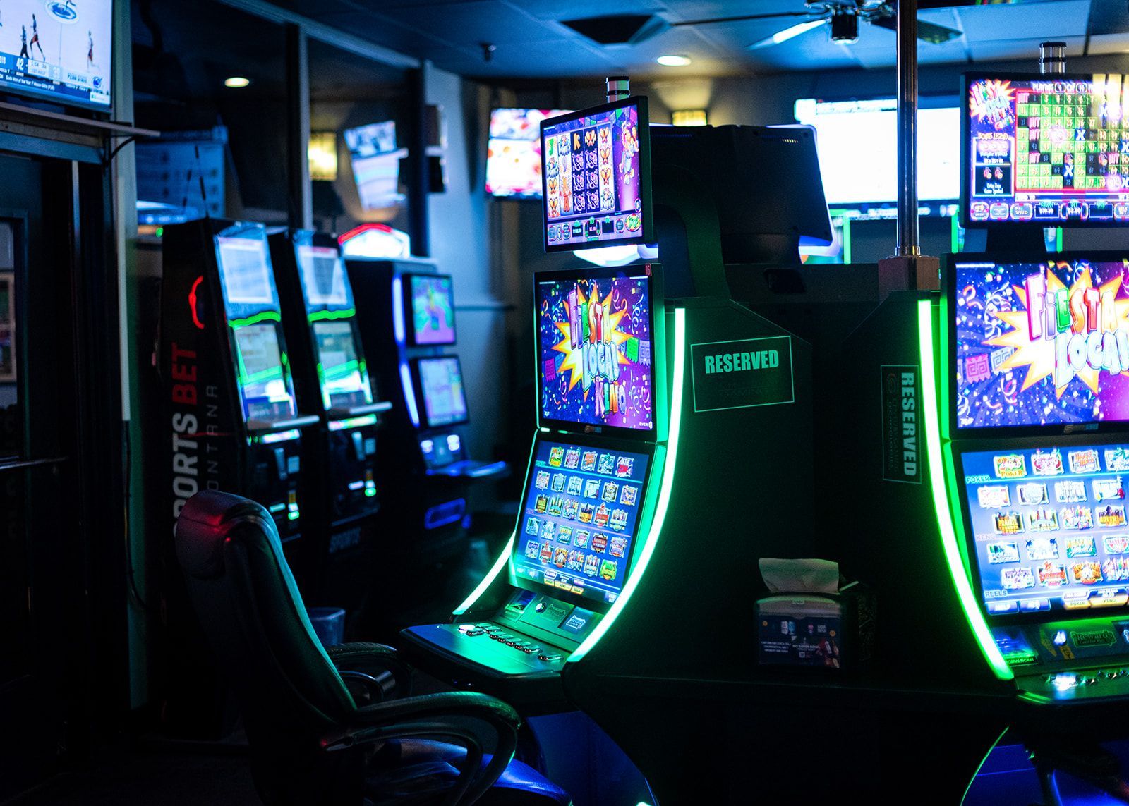 A row of slot machines in a casino with a sign that says sports bet