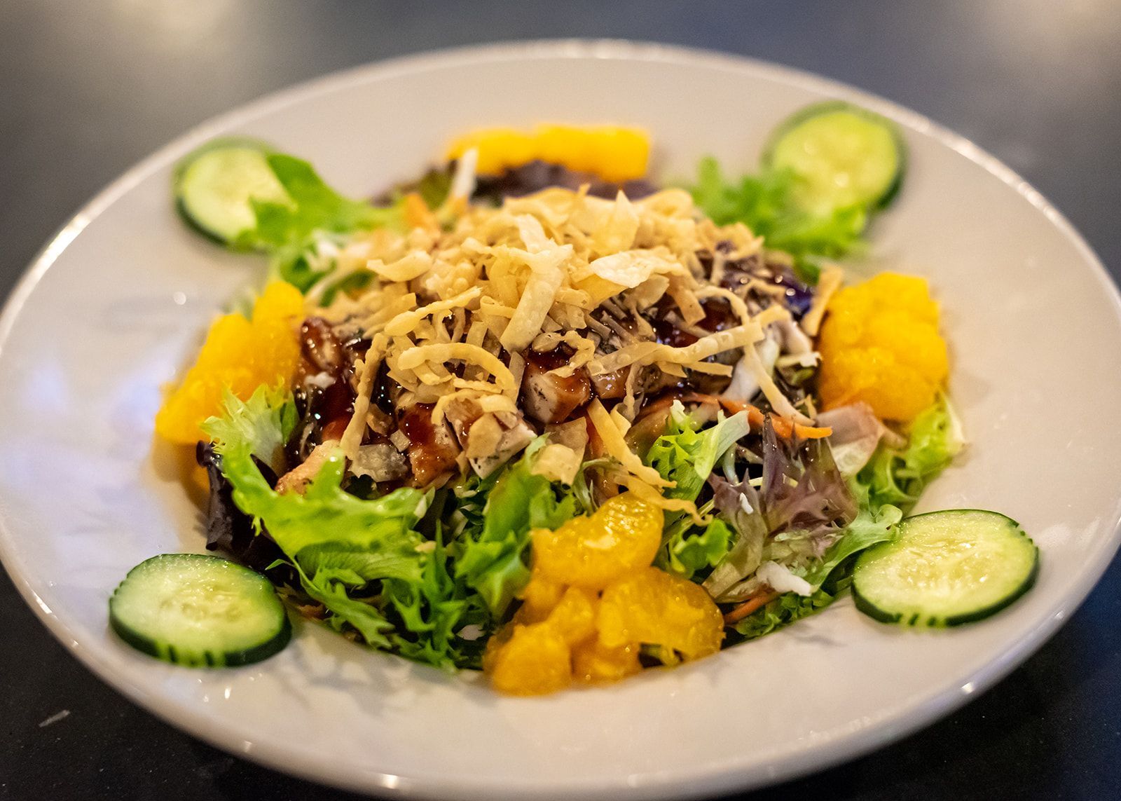 A close up of a salad on a plate on a table.