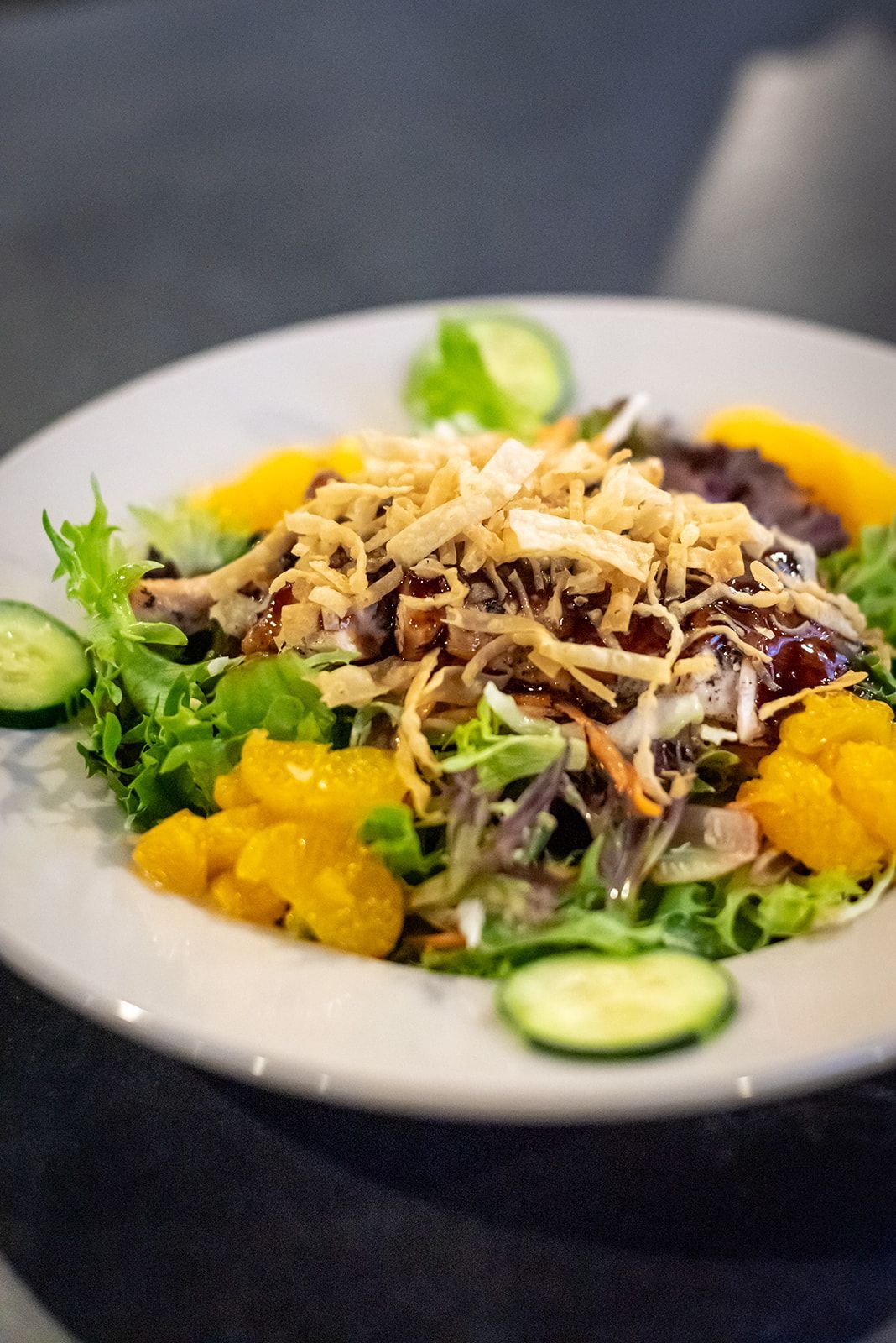 A close up of a salad on a plate on a table.