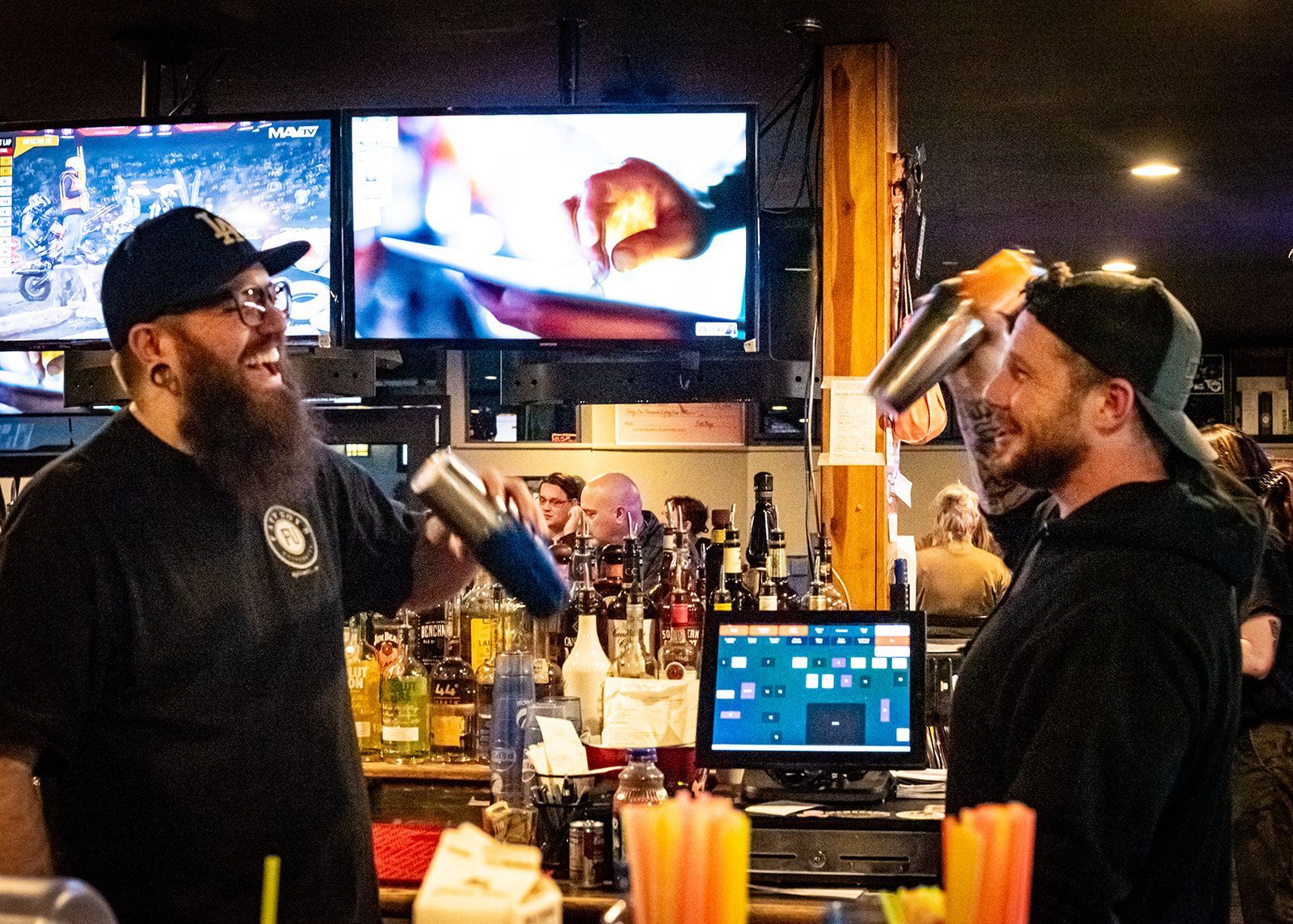 Two men are shaking drinks in a bar.